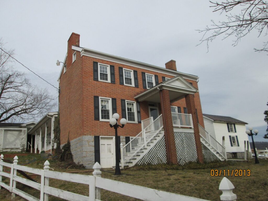 Three-story brick Christian Myers home with a two-level front porch